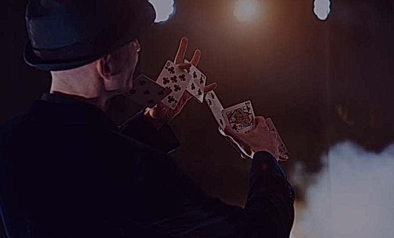 De goochelaar toont een truc met speelkaarten.